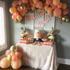 a table topped with lots of cake and balloons