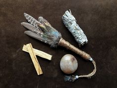 feathers, beads and other items laid out on a brown table top with one bead in the middle