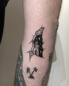 a man's arm with a small house tattoo on it