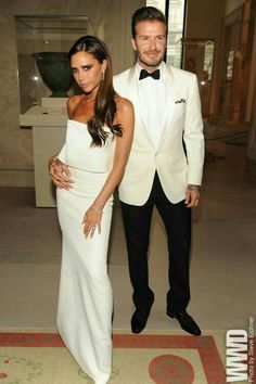 a man in a tuxedo standing next to a woman in a white dress