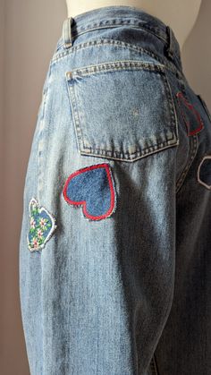 the back of a woman's jeans with patches and hearts on them, showing how to sew