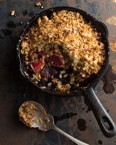 a skillet filled with oatmeal and fruit on top of a table