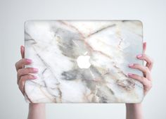 a woman holding an apple laptop in her hands