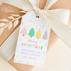 a gift wrapped in brown paper with a white ribbon and tag that says merry christmas