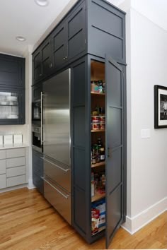 a pantry in the middle of a kitchen with stainless steel appliances and drawers on both sides