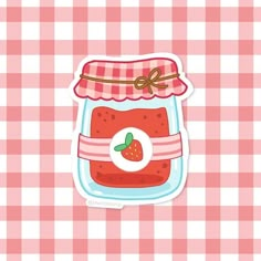 a strawberry jam sticker sitting on top of a pink checkered tablecloth background