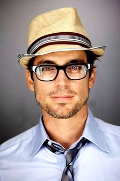 a man wearing glasses and a hat poses for a black and white photo with a tie