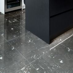 a kitchen with marble floors and black cabinets