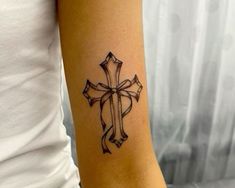 a woman with a cross tattoo on her arm