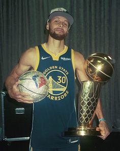 a man holding a basketball and trophy in his hands