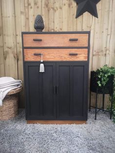 a black and brown dresser with two drawers on top of it next to a basket