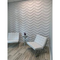 two chairs and a table in front of a wall that has wavy waves on it