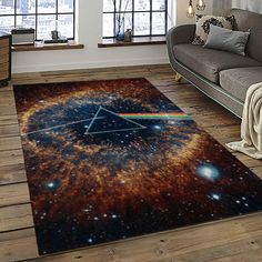 a living room with a couch, chair and rug that has the dark side of the moon on it