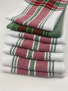 four red, green and white towels stacked on top of each other in different patterns