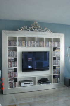 a large entertainment center with many bookshelves and movies on the shelves in front of it