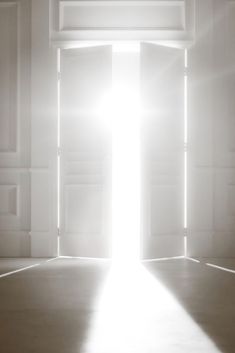 an open door with the light coming in from it's center and shining into the room