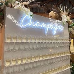 champagne glasses are lined up in front of a large sign that reads champagne on it