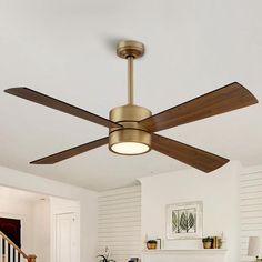 a ceiling fan in a living room with white walls and wood trimmings on the ceiling