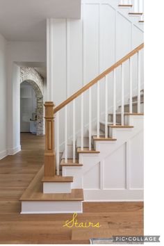 a staircase with white walls and wood handrails