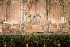 an elaborately decorated stage set up with flowers and candles