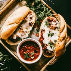 two sandwiches with meat and sauce in a tray