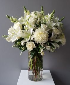 a vase filled with white flowers on top of a table