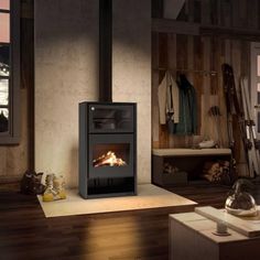 a wood burning stove sitting inside of a living room next to a wooden floor and wall