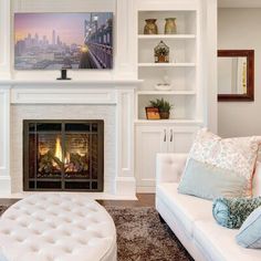 a living room filled with furniture and a fire place in front of a white fireplace