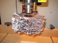 a machine that is cutting some paper with it's bladed end on the table