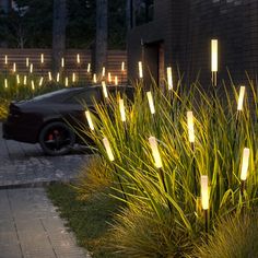 some lights that are on the side of a building and grass in front of it