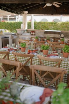 an outdoor dining area with tables and chairs covered in green checkered tablecloths