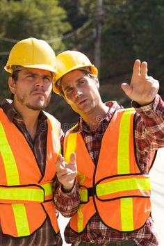 two men in safety vests giving the peace sign with their hands royalty images and stock photos