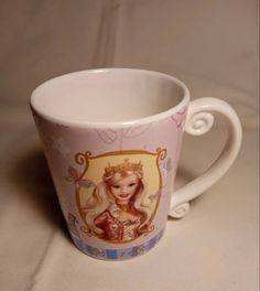 a coffee cup with an image of a princess on the front and sides, sitting on a table