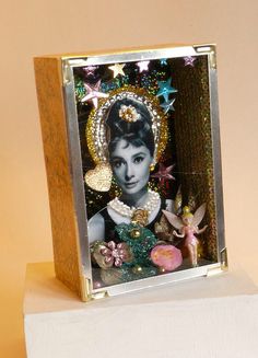 a small photo frame with a woman's face in the center, surrounded by stars and other decorations