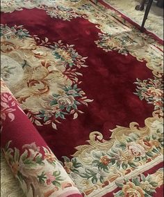 a red rug with floral designs on it