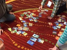 three children are playing with cards on the floor