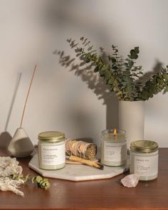 some candles are sitting on a table next to a potted plant and other items