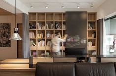 a living room filled with furniture and bookshelves next to a large glass window