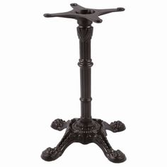 a black metal table with an ornate design on the top and base, standing upright