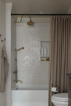 a bathroom with a tub, toilet and shower curtain