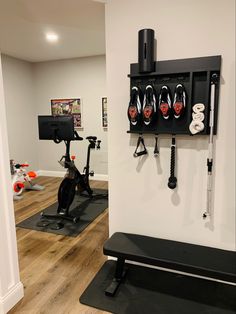 a home gym with exercise equipment and personal training equipment on the wall, including an exercise bike