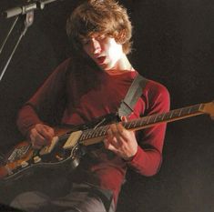 a young man playing an electric guitar on stage