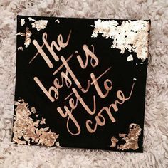 the best is yet to come written on a piece of black and gold foiled paper