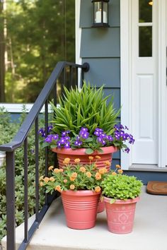 three flower pots are sitting on the front porch