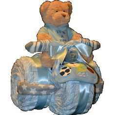 a teddy bear is sitting on top of a toy car that says it's a boy