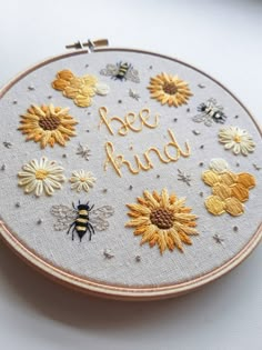 a close up of a embroidery on a hoop with bees and sunflowers in it