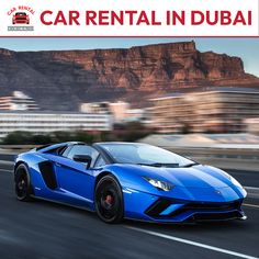 a blue sports car is driving down the road in front of some buildings and mountains