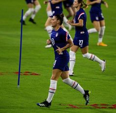 the women's soccer team is running on the field