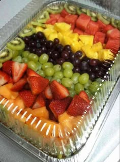 a tray filled with lots of different types of fruit on top of plastic wrappers