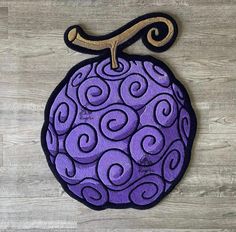 a purple and black patch with swirls on it, hanging from a wooden wall